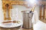 Champagne in silver bucket next to champagne flutes