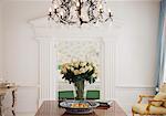 Chandelier above rose bouquet on table in luxury foyer