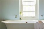 Soaking tub below window in luxury bathroom