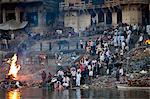 Body bathed in River Ganges and traditional Hindu cremation on funeral pyre at Manikarnika Ghat in Holy City of Varanasi, Benares, India