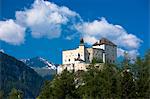 Tarasp Castle surrounded by larch forest in the Lower Engadine Valley, Switzerland, Europe