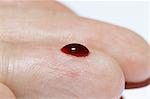 (Synthetic) Blood drop on a male finger