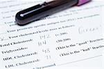 Test tube filled with blood and cholesterol test form document