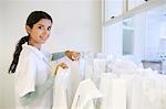 Portrait of young female pharmacist checking prescription bags