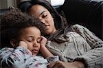 Two sisters asleep on sofa