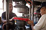 Hat makers stretching fabric on mould in workshop