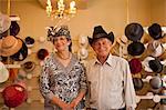 Portrait of senior couple in traditional milliners shop