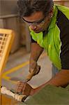 Carpenter turning wood with chisel in workshop