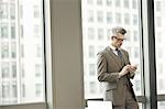 Businessman texting on smartphone in office