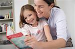 Mother and young daughter reading storybook