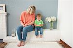 Young woman and baby boy playing with flowers