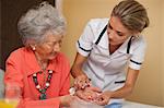 Care assistant handing medication to senior woman