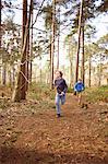 Twin brothers racing each other through forest