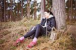 Mature woman runner talking on her cellphone in a forest