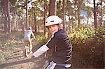 Twin brothers on BMX bikes in forest