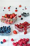 blueberries, blackberries, raspberries, strawberries, redcurrants on a white table