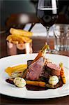 Roast lamb with carrots, chips, a glass of red wine