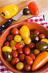 Cherry tomatoes and peppers in a bowl and on a chopping board