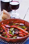 Peppers with chorizo, served with bread and red wine (Spain)