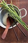 Rice and ears of rice, a wooden spoon and chopsticks in a pan of rice