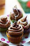 Chocolate cupcakes with sugar pearls on a cake stand