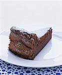 A slice of chocolate cake with icing sugar