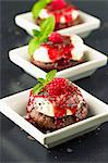 Cupcakes with cream cheese topping, raspberry sauce and grated chocolate