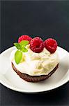 Cupcake with cream cheese topping and fresh raspberries