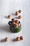 Walnuts in a ceramic jug and to one side