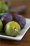 Plums and greengages on a square plate