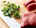 Raw Beef and Chopped Cilantro on a Wooden Cutting Board