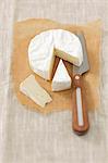 Camembert on grease-proof paper, partly sliced