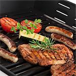 Pork steaks, sausages and vegetables on the grill