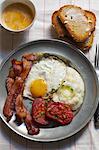 Breakfast; Eggs, Bacon, Grits, Stewed Tomatoes and a Side of Toast with Coffee