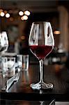 A glass of red wine on a table in a restaurant