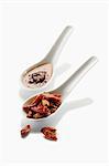 Two spoons with dried chillies and chilli oil