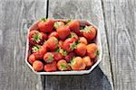 Close-up of freshly picked strawberries in box container on table outdoors, Germany