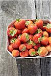 Close-up of freshly picked strawberries in box container on table outdoors, Germany