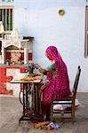 Indian woman wearing traditional Rajasthani sari works at home using sewing machine in village of Nimaj, Rajasthan, Northern India