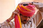 Hindu ceremonial guard putting on Rajasthani turban at Mehrangarh Fort at Jodhpur in Rajasthan, Northern India