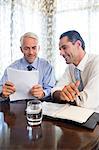 Businessmen doing paperwork at office desk