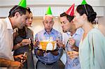 Happy group of people with champagne flutes and cake