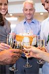 Closeup of people with champagne flutes and cake