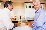 Business colleagues with beer glasses at bar counter