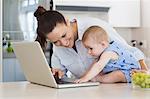 Mother and baby using laptop at counter