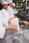 Chefs preparing dough at counter