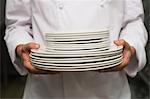 Chef holding stack of plates