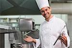 Chef holding a lid smiling at camera