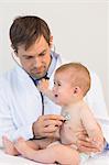Handsome pediatrician checking baby boy