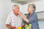 Happy senior couple preparing vegetables